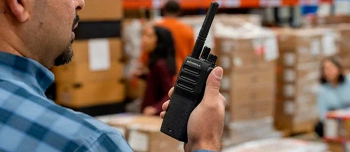 Utilisateur en entrepôt utilisant un talkie-walkie radio longue portée avec licence