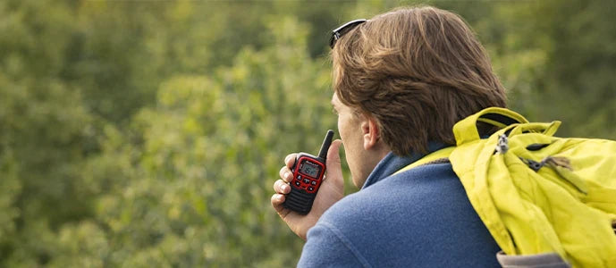 Utilisateur en randonnée utilisant un talkie-walkie pour communication en extérieur